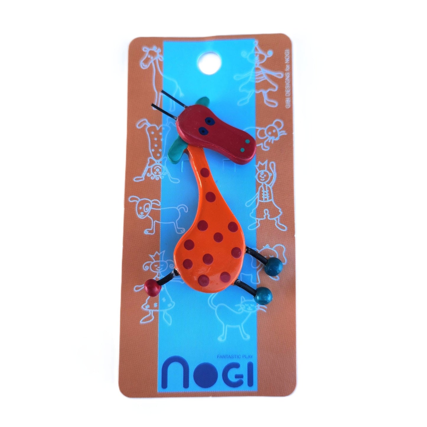 Wooden pin of an orange giraffe with red spots and a red face on Nogi branded packaging
