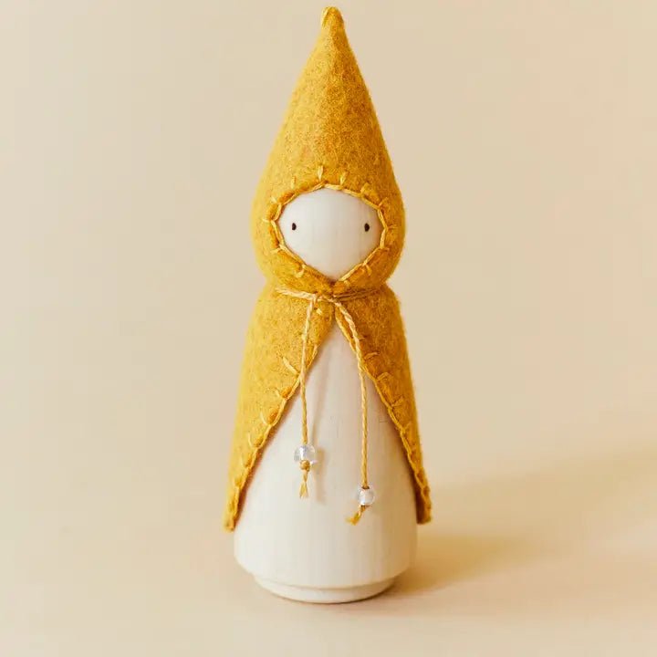 Wooden gnome figure with a yellow hood and coat on a beige background
