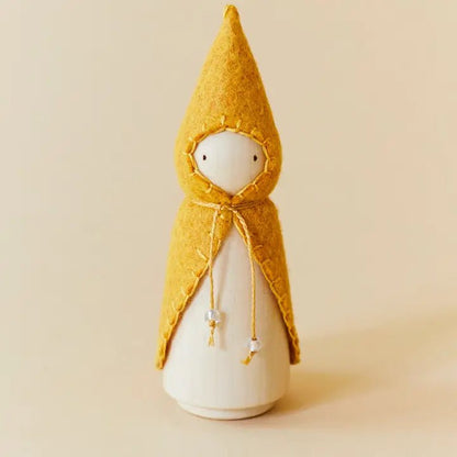 Wooden gnome figure with a yellow hood and coat on a beige background