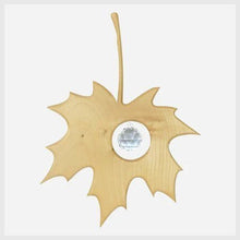 Wooden maple leaf-shaped ornament with a crystal center on a white background
