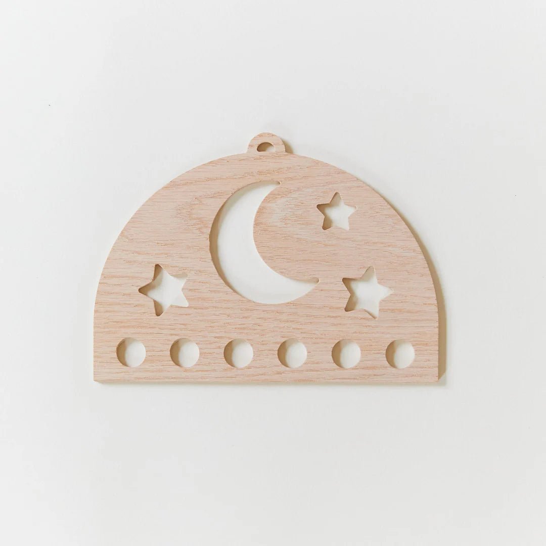 Wooden silk display with star and moon cutouts on a white background