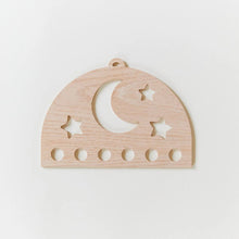 Wooden silk display with star and moon cutouts on a white background