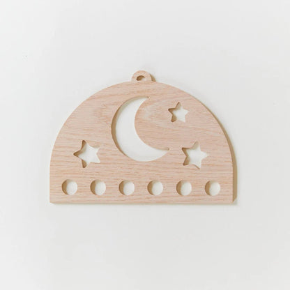 Wooden silk display with star and moon cutouts on a white background