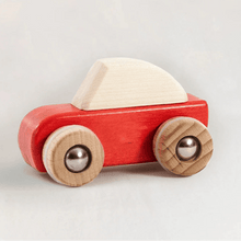 Red wooden car with a white top on a light background