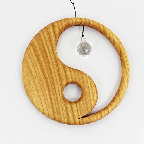 Wooden yin yang suncatcher with a crystal pendant on a white background