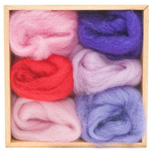 6 rolls of felting wool in various shades of pink and purple in a wooden storage box