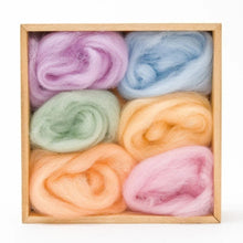 6 balls of wool in pastel shades in a wooden storage box on a white background